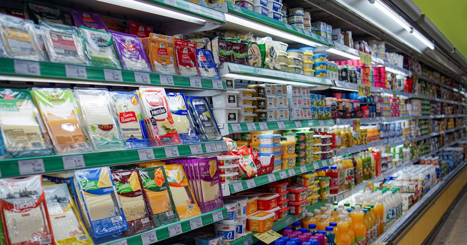 Alejka supermarketu z półkami zapełnionymi produktami spożywczymi.
